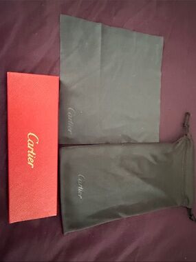 Cartier red box with gold logo and black drawstring pouches